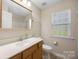 Traditional bathroom featuring a wooden vanity with a large mirror and a window providing natural light at 4323 Wiregrass Rd, Indian Land, SC 29707