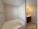 Corner soaking tub in a bright bathroom with tile flooring and neutral paint at 5011 Abercromby St, Charlotte, NC 28213