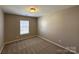 Carpeted bedroom with a bright window and neutral paint at 5011 Abercromby St, Charlotte, NC 28213