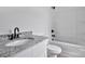 A bathroom features a granite vanity countertop, a toilet, and a bathtub with matte black hardware at 515 Harrel St, Salisbury, NC 28144
