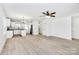 Open-concept area, featuring new flooring, a ceiling fan, and a partial view of the kitchen at 515 Harrel St, Salisbury, NC 28144