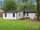 Backyard view showcasing the home's exterior with a well-kept lawn and mature trees at 5316 Rupert Ln, Charlotte, NC 28215