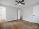 Bedroom featuring wood floors, light grey walls, closet and an attached bathroom with tiled shower at 5316 Rupert Ln, Charlotte, NC 28215