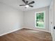 Bedroom with ceiling fan, wood floors, light grey walls and a window with backyard view at 5316 Rupert Ln, Charlotte, NC 28215