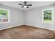 Bedroom with ceiling fan, light grey walls, wood floors and dual windows providing backyard views at 5316 Rupert Ln, Charlotte, NC 28215
