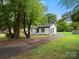 View of home exterior, surrounded by mature trees and a long driveway at 5316 Rupert Ln, Charlotte, NC 28215
