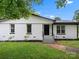 Charming white brick home with black trim, landscaped front yard, and inviting entryway steps at 5316 Rupert Ln, Charlotte, NC 28215