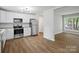 A modern kitchen featuring stainless steel appliances, white cabinetry, and wood-look flooring at 5316 Rupert Ln, Charlotte, NC 28215