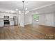 Bright living room showcasing an open-concept design, wood flooring, and a modern light fixture at 5316 Rupert Ln, Charlotte, NC 28215