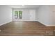 Bright living room featuring new flooring, fresh paint, a large window, and modern door at 5316 Rupert Ln, Charlotte, NC 28215