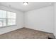 A bright bedroom features a large window, plush carpet, and a modern ceiling fan at 5524 Howard St, Charlotte, NC 28269