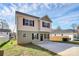 Charming two-story home featuring a combination of beige and green siding, complemented by dark shutters and concrete driveway at 5524 Howard St, Charlotte, NC 28269