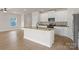 Bright kitchen featuring a center island, granite countertops, stainless steel appliances, and hardwood floors at 5704 Skinny Dr, Charlotte, NC 28215