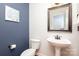 Charming half bathroom featuring a pedestal sink, toilet, and decorative wall art at 615 Vega Nw St, Concord, NC 28027