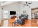 Well-lit living room featuring hardwood floors, vaulted ceiling, and comfortable seating arrangements at 615 Vega Nw St, Concord, NC 28027