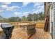 View of the wooden deck with table, chairs, grill and the wooded back yard at 619 N Skyland Dr, Mount Pleasant, NC 28124