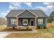 Attractive single-story home featuring a welcoming front porch, American flag, and neat landscaping at 619 N Skyland Dr, Mount Pleasant, NC 28124