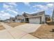 A suburban house features a two-car garage, gray siding, stone accents, and a large driveway at 6419 Cambridge Dr, Harrisburg, NC 28075