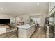 A modern kitchen featuring stainless steel appliances, a spacious island with a sink, and an adjacent living space at 6419 Cambridge Dr, Harrisburg, NC 28075