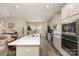 A modern kitchen featuring stainless steel appliances, a spacious island with a sink, and an adjacent living space at 6419 Cambridge Dr, Harrisburg, NC 28075