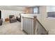 A cozy upstairs loft area features a comfortable gray sofa, accent pillows, a large clock and natural light at 6419 Cambridge Dr, Harrisburg, NC 28075