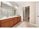 This bathroom has dual sinks, wood cabinets and an entry to the tile shower room at 7909 Parknoll Dr, Huntersville, NC 28078