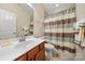 A cozy bathroom featuring a wooden vanity and a striped shower curtain at 7909 Parknoll Dr, Huntersville, NC 28078