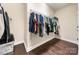 A walk-in closet features hardwood floors, built in shelves and rods for storage at 7909 Parknoll Dr, Huntersville, NC 28078