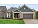 Charming home exterior featuring stone accents, a two-car garage, manicured lawn, and a welcoming covered front entrance at 7909 Parknoll Dr, Huntersville, NC 28078