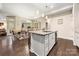 The modern kitchen features an island with bar seating, stone countertops, and access to the dining room at 7909 Parknoll Dr, Huntersville, NC 28078