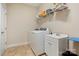 Well-lit laundry room has utility sink and shelving above the washer and dryer hookups at 7909 Parknoll Dr, Huntersville, NC 28078