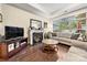 Inviting living room with a cozy fireplace, hardwood floors, neutral sofas, and a TV at 7909 Parknoll Dr, Huntersville, NC 28078