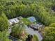 Aerial view of the community's amenities, including a pool and tennis courts, surrounded by lush trees at 9009 Stourbridge Dr, Huntersville, NC 28078