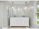 Bright bathroom featuring a double sink vanity with marble countertop and modern light fixtures at 9009 Stourbridge Dr, Huntersville, NC 28078