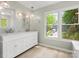 Bright bathroom with double vanity, marble countertop, and a view of the outdoors at 9009 Stourbridge Dr, Huntersville, NC 28078