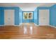 Light blue bedroom with hardwood floors, two closet doors, and a window at 9009 Stourbridge Dr, Huntersville, NC 28078