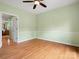A spacious bedroom featuring hardwood flooring, light green walls, and a ceiling fan at 9009 Stourbridge Dr, Huntersville, NC 28078