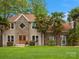 Charming home featuring stone accents, a manicured lawn, and mature landscaping with palm trees at 9009 Stourbridge Dr, Huntersville, NC 28078