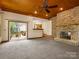 Cozy living room featuring a stone fireplace, carpet, and access to the back deck at 9009 Stourbridge Dr, Huntersville, NC 28078