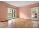 Bright, empty living room boasts hardwood floors and natural light from two windows at 9009 Stourbridge Dr, Huntersville, NC 28078