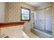 Bathroom with tiled shower, large window, floral wallpaper and single sink at 9951 Providence Forest Ln, Charlotte, NC 28270