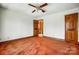 Bedroom features ceiling fan, wood baseboard, door to hallway and second door at 9951 Providence Forest Ln, Charlotte, NC 28270