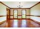 Classic dining room with hardwood floors, decorative wallpaper, two large windows, and a chandelier at 9951 Providence Forest Ln, Charlotte, NC 28270