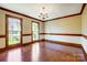 Elegant dining room with hardwood floors, ornate trim, wainscoting, and large windows providing ample natural light at 9951 Providence Forest Ln, Charlotte, NC 28270