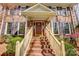 Inviting entryway with brick steps leading to a covered porch, accented by elegant trim and sidelight windows at 9951 Providence Forest Ln, Charlotte, NC 28270