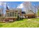 Back exterior view showcasing brick facade, sunroom, and well-maintained lawn at 9951 Providence Forest Ln, Charlotte, NC 28270