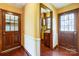 Warm entryway with wood floors, contrasting doors, and a view into the laundry room at 9951 Providence Forest Ln, Charlotte, NC 28270