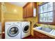 Functional laundry room with modern washer and dryer, sink, and storage, perfect for efficient chores at 9951 Providence Forest Ln, Charlotte, NC 28270