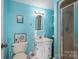 Blue bathroom featuring a toilet, sink with mirror, and a shower with glass doors at 108 N Oakwood Dr, Kings Mountain, NC 28086