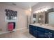 Bathroom featuring blue cabinets, a window with a floral valence and a shower with glass doors at 108 N Oakwood Dr, Kings Mountain, NC 28086